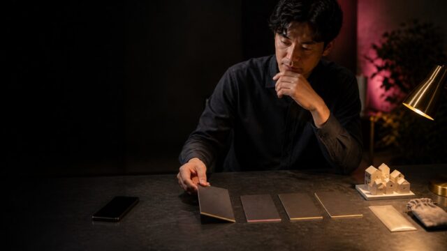 四つの候補を机に並べ課金前の条件を見比べる成人男性